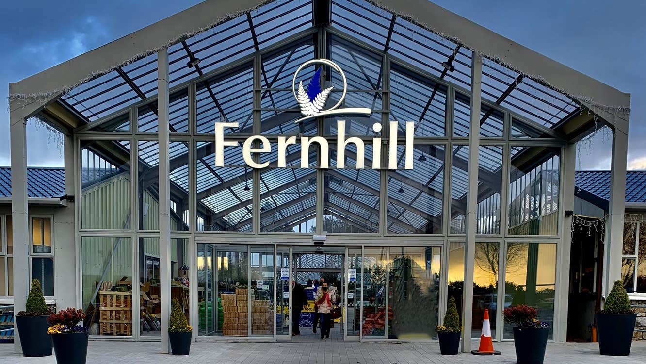 Exterior of a glass garden centre with a road and a pedestrian crossing in front