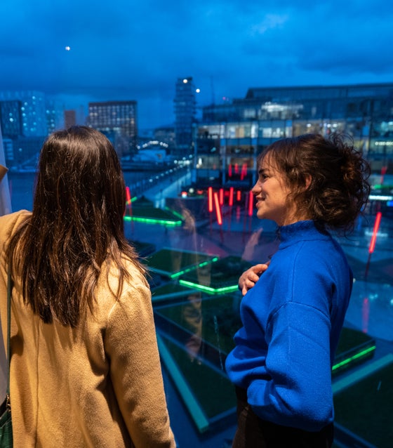 Two women looking out at Grand Canal Dock from the Marker Hotel in Dublin city