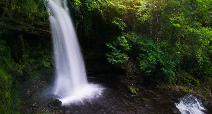 A waterfall cascading past rich greenery
