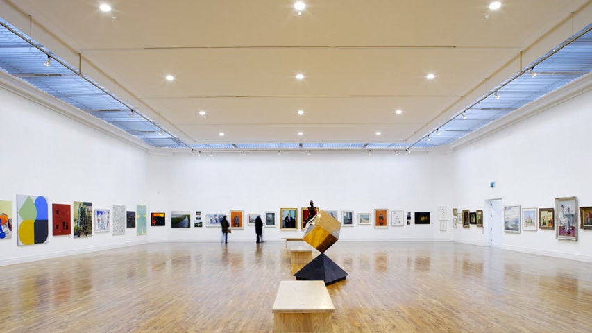 A gallery with artworks on the walls and a sculpture in the centre of the room