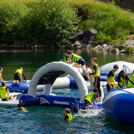 A floating obstacle course on a lake with people on it
