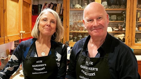 Two people in aprons posing with their dishes