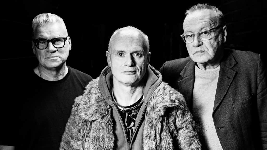 Black and white image of 3 older, unsmiling men.