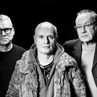 Black and white image of 3 older, unsmiling men.