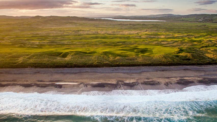 A panoramic view of Ballyliffin Golf Club with the sea in the foreground
