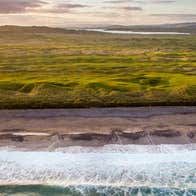 A panoramic view of Ballyliffin Golf Club with the sea in the foreground