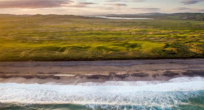 A panoramic view of Ballyliffin Golf Club with the sea in the foreground