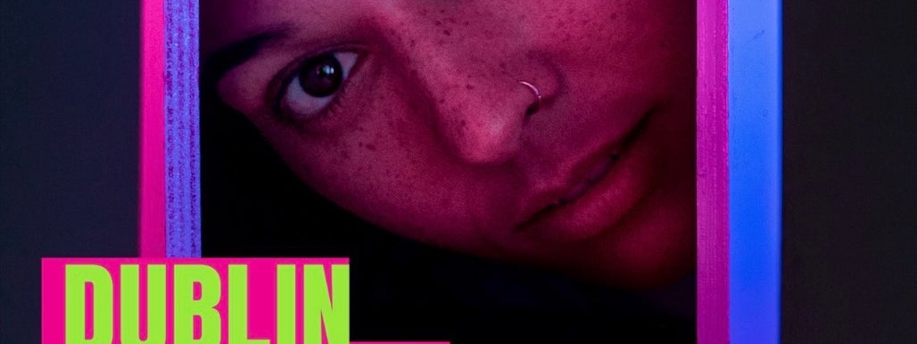A close-up portrait peers through a rectangular frame, lit in vivid pink, purple and blue. Neon green and hot pink graphics read “Dublin Fringe Festival”, “GRETEL, TAN & JWY”, “Make the City Yours” and “5–20 September”.