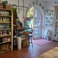 The interior of a decorated pottery studio with shelves of ceramics and benches