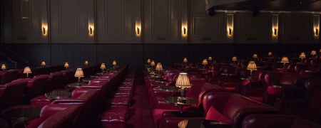 A view of seats in a cinema with old fashioned side tables and lamps