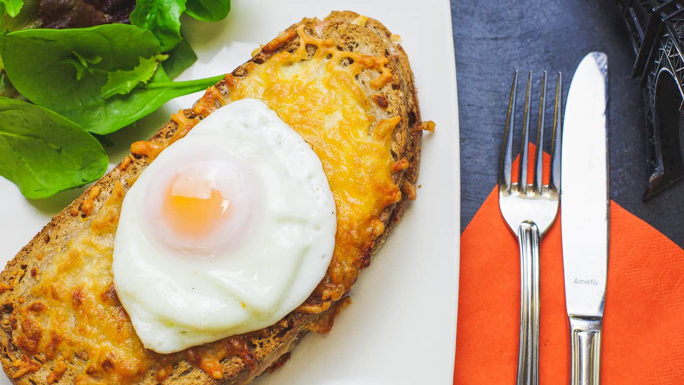 A poached egg sitting on a slice of artisan bread on a plate