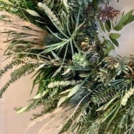 Part view of green foliage as part of a wreath.