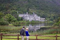 A couple looking at Kylemore Abbey in Connemara in County Galway.