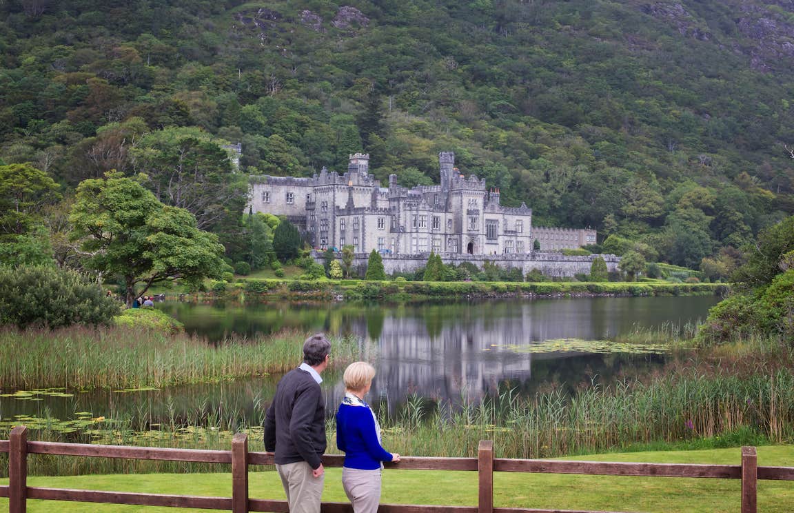 A couple looking at Kylemore Abbey in Connemara in County Galway.