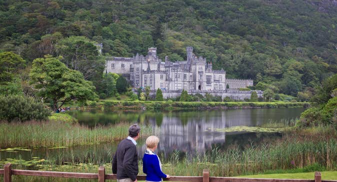 A couple looking at Kylemore Abbey in Connemara in County Galway.