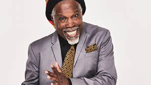 A smiling man in a grey suit