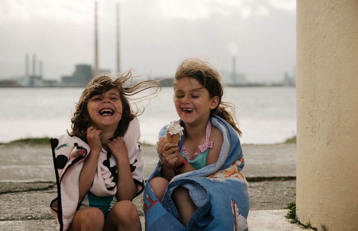 Two girls laughing and eating ice cream cones