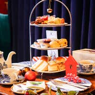 Festive Afternoon Tea stand at Old Music Shop restaurant, the Castle Hotel. Sandwiches, pastries, scone, selection of teas, gifts, Christmas decorations place on a table.