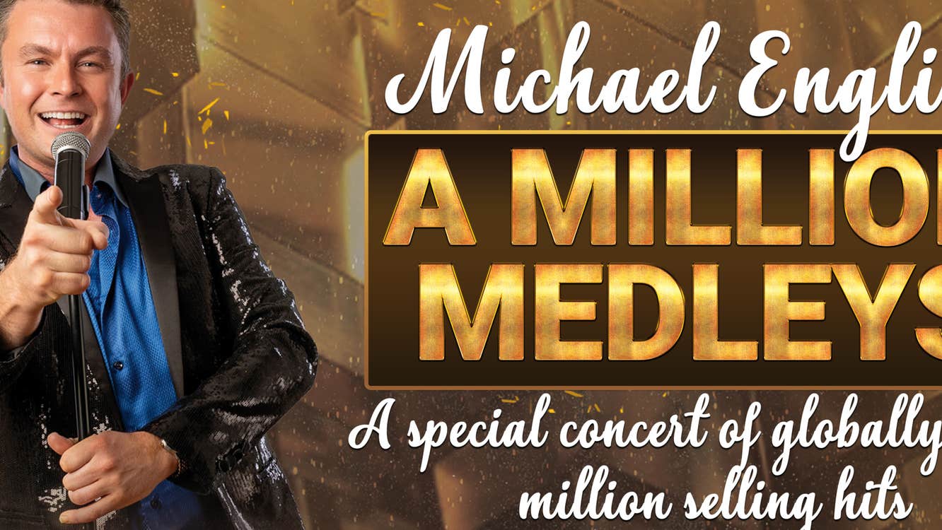 Gold and brown poster with man to left side in shiny dark jacket holding a mic smiling and pointing forward.