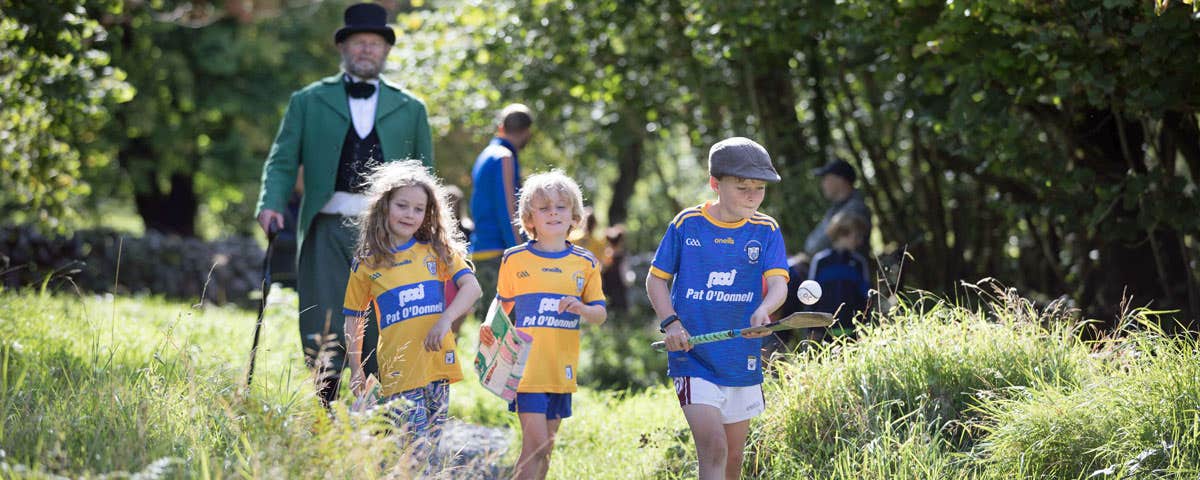 Image of three children and gentleman on a field walking trip on the Cusack Way