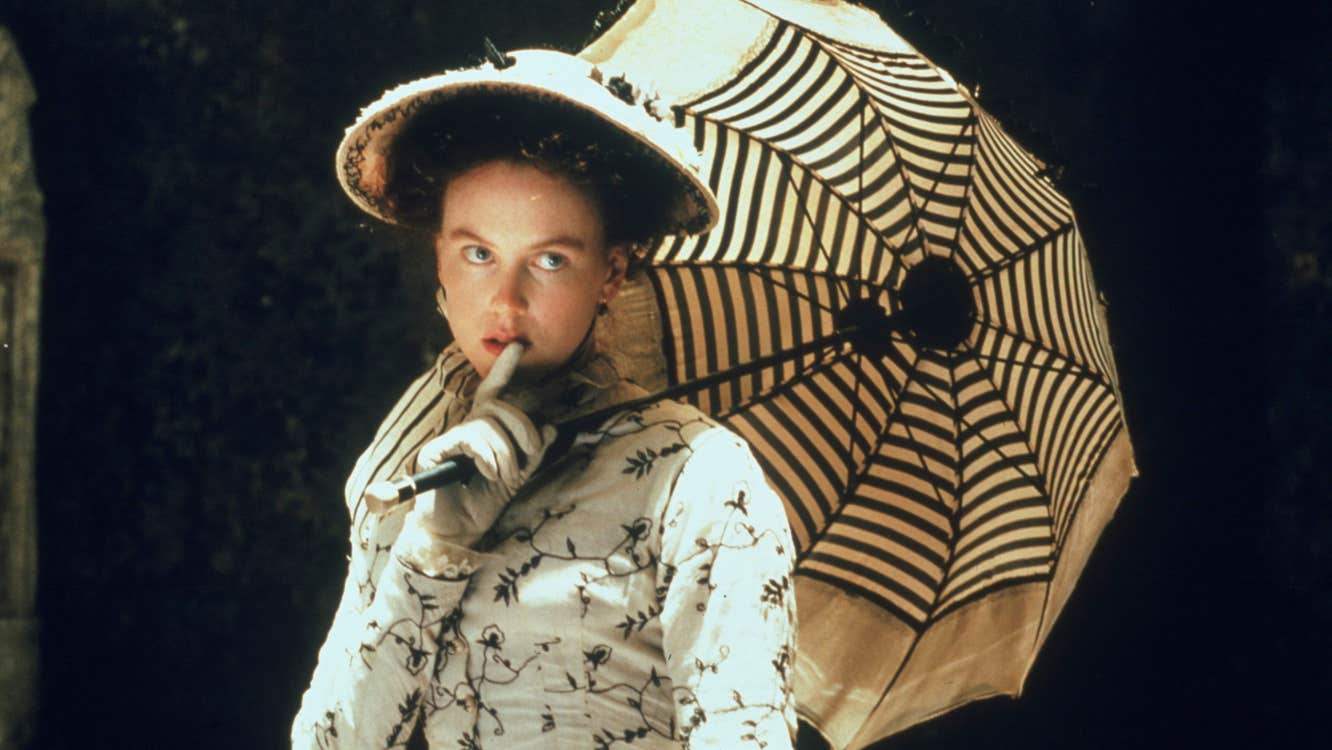 A well-dressed woman with a hat and parasol.