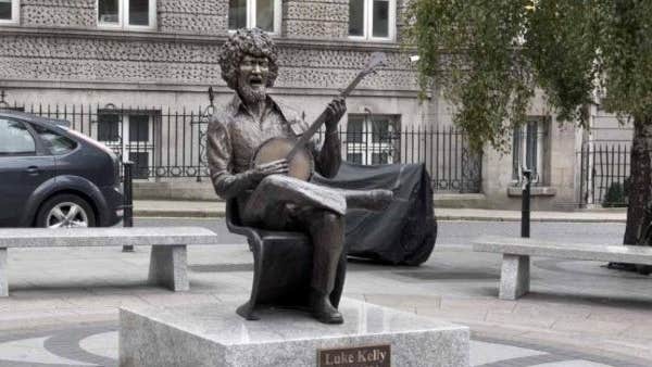 Statue of Luke Kelly seated and playing banjo