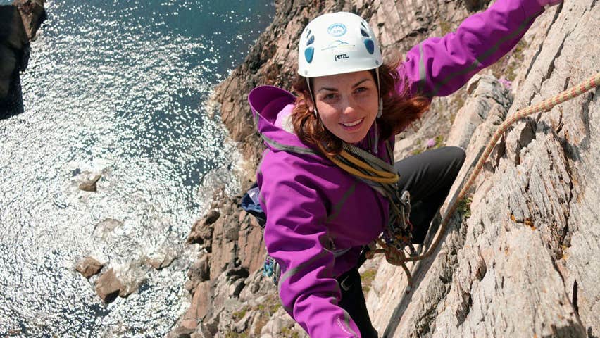 Girl climbing rockface at Donegal Climbing Muff Malin Head County Donegal