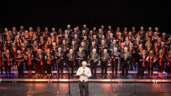 The Bray Community Choir on a large stage with conductor