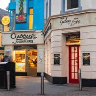 A street view of Claddagh Jewellers with people walking along the street