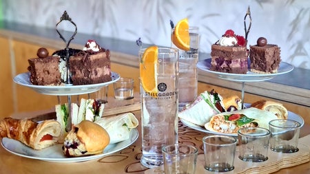 Stillgarden Distillery view of afternoon tea with cakes and sandwiches and gin tasting