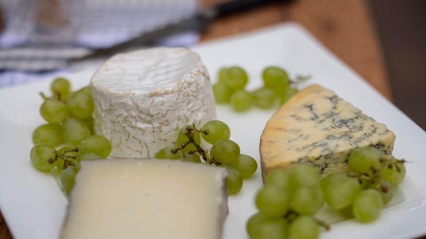 Cheese and grapes on a plate.