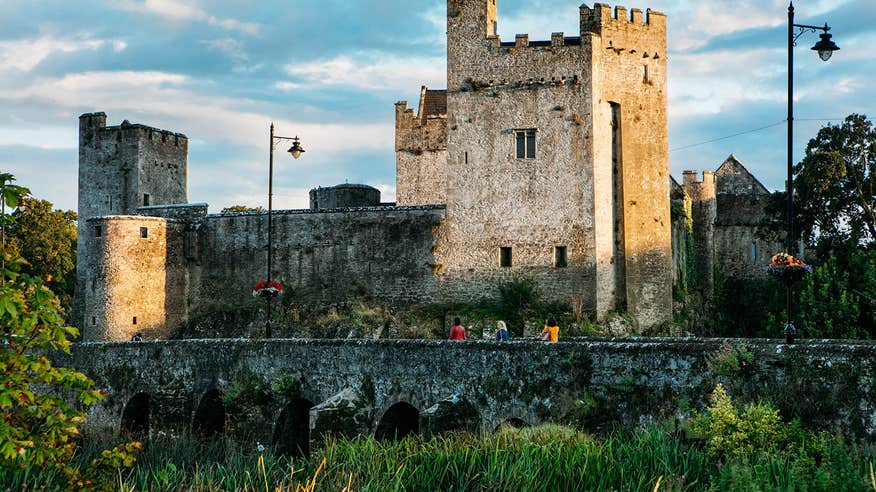 A group of people walking over a bridge to Cahir Castle, Tipperary