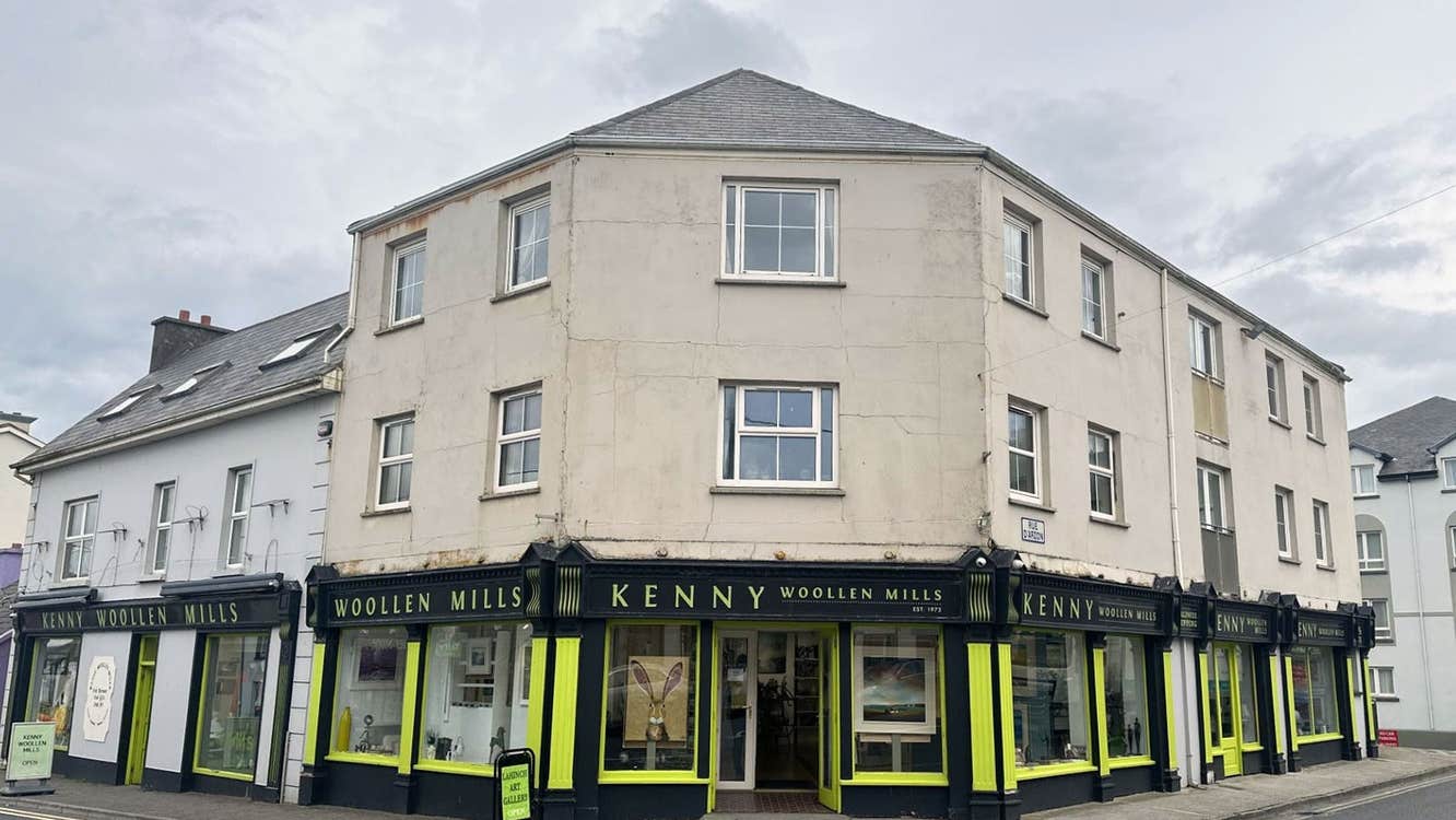 Black and yellow painted shop front with and windows and an open door
