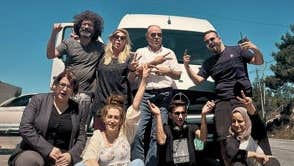 Film - Palestine Comedy Club, a group of 7 people at the front of a white van on a sunny day.