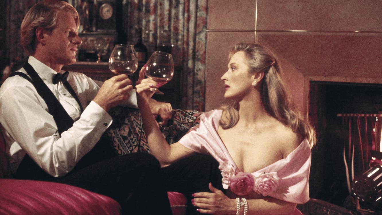 An opulently dressed couple clinking glasses.