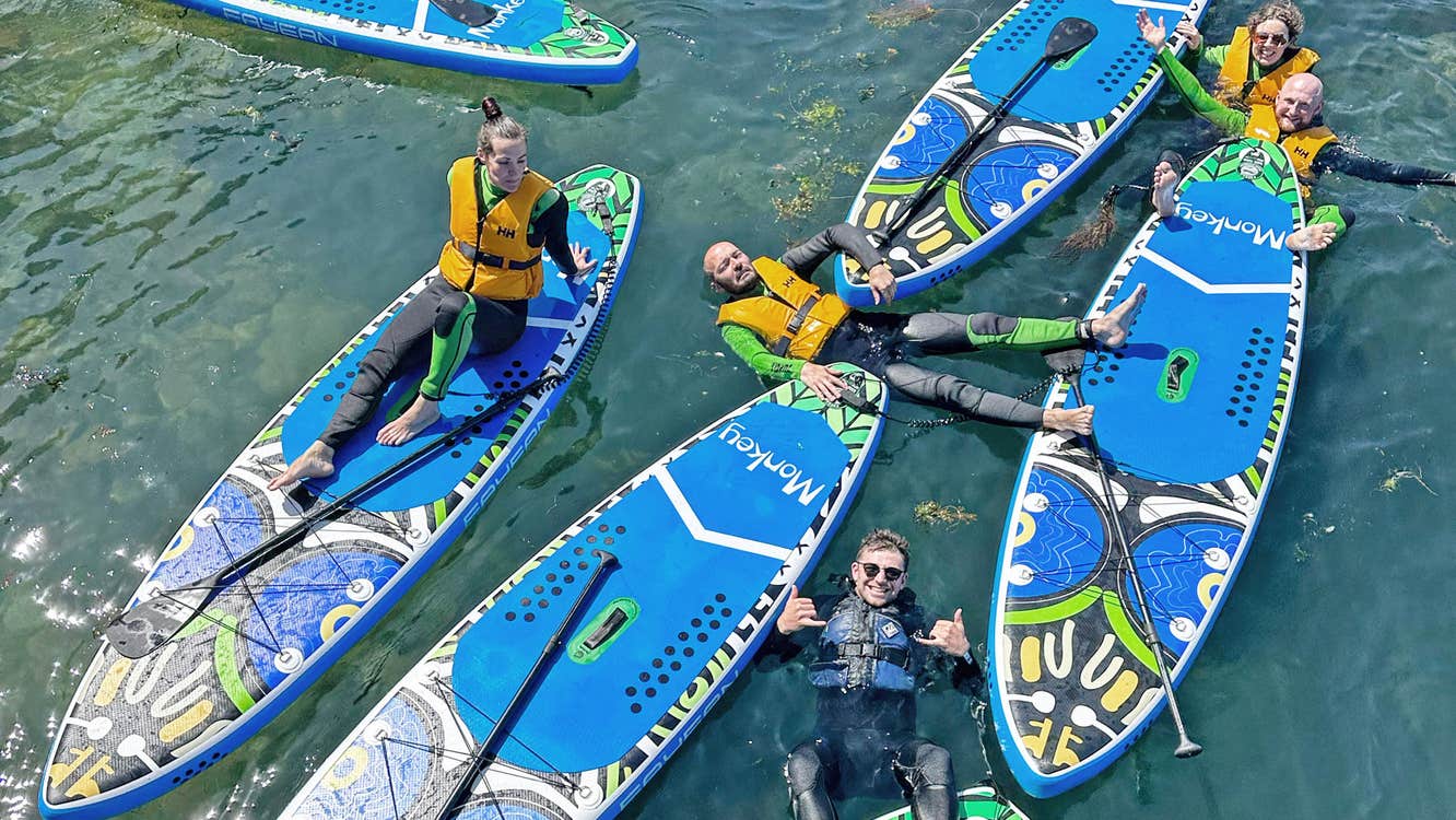 Jungle SUP overhead view of six blue paddle boards and people in the water