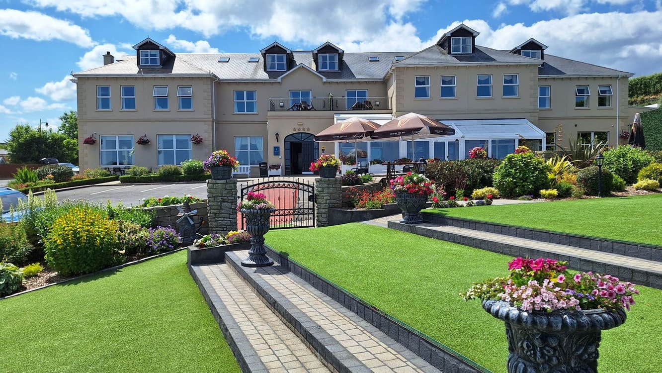 Ballyliffin Lodge hotel exterior with landscaped gardens and terrace seating