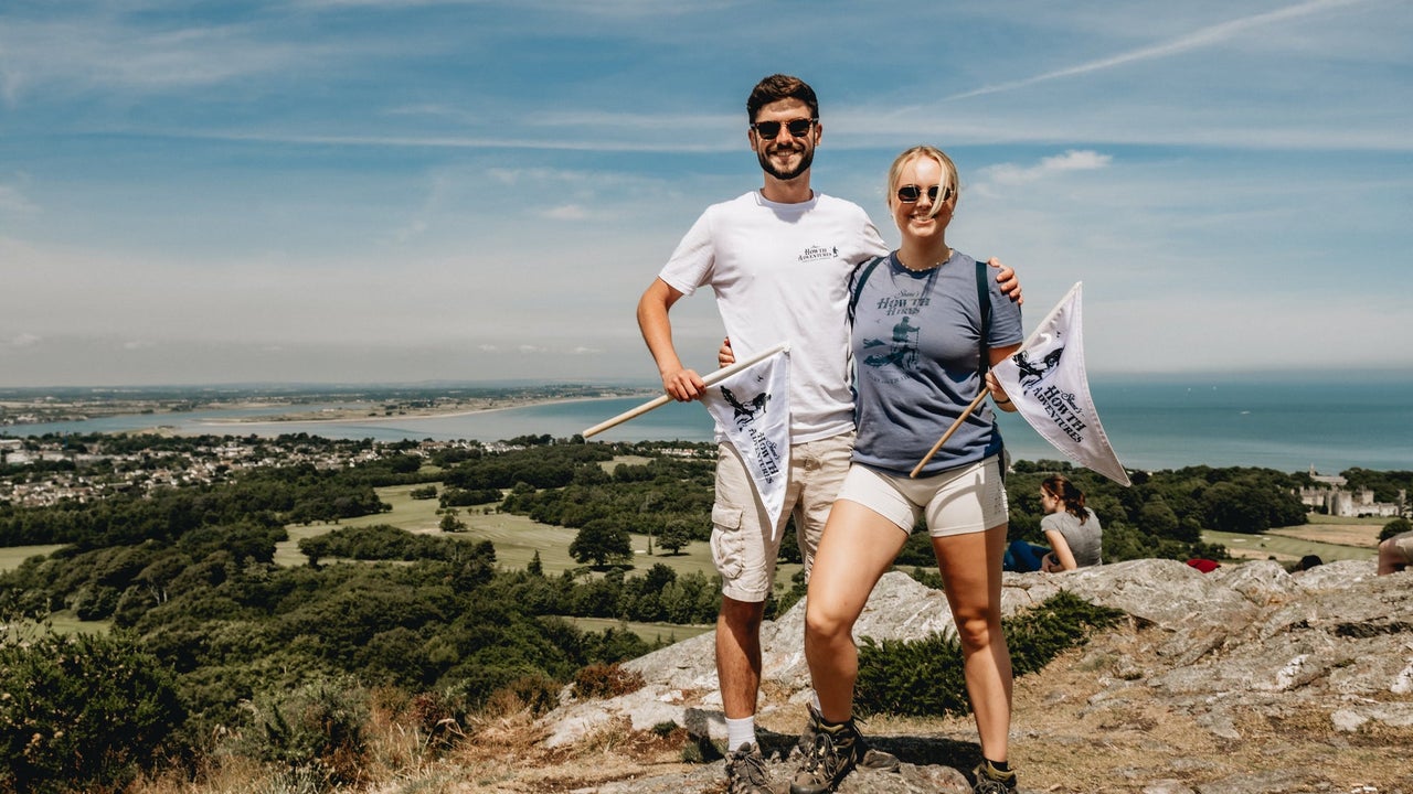 Two people standing on the top of a hill on a sunny day