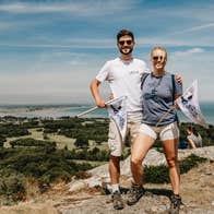 Two people standing on the top of a hill on a sunny day