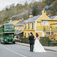 Bride and groom walking towards Wright's Anglers Rest where a green double decker bus is parked outside