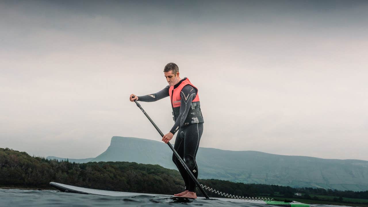 A man on the water stand up paddle boarding with Sligo Bay Sup