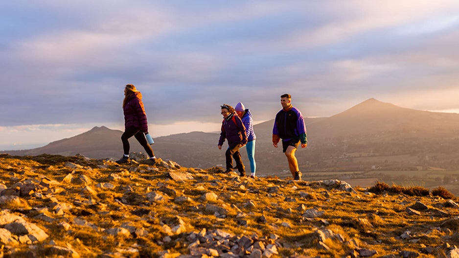 Group of 4 friends hiking in the Dublin Mountains at sunset.