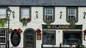 Exterior of a traditional two storey building with flower displays and signage for a bistro