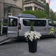 A wheelchair accessible taxi parked outside a hotel with Dublin Wheelchair Taxis