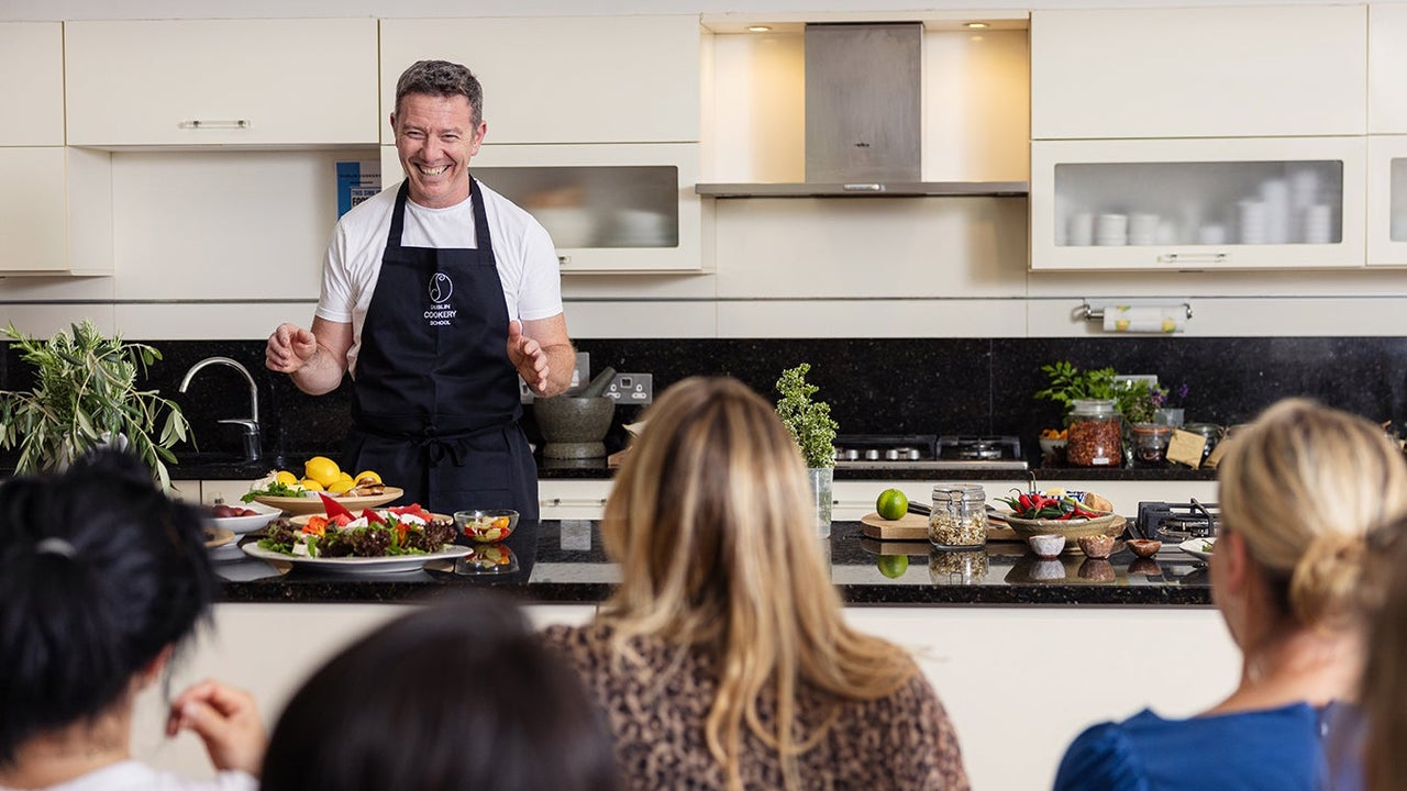 A chef smiling at his class during a cookery demonstration