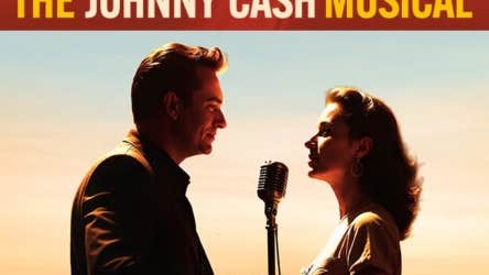 2 people viewed from the side singing into a mic on stand between them.