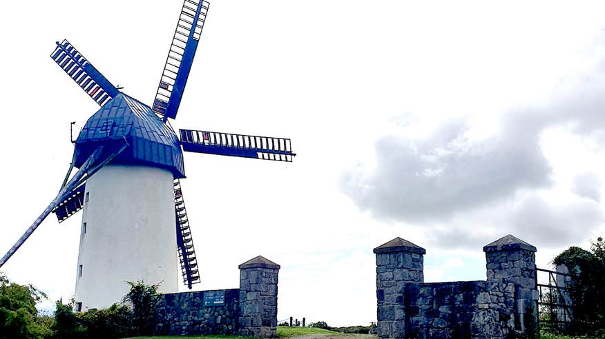 Blue windmill behind a stone wall at Skerries Mills in Dublin.