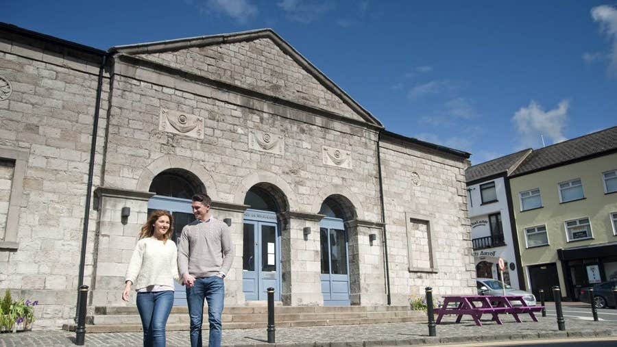 A couple walking in front of The Market House in Monaghan Town