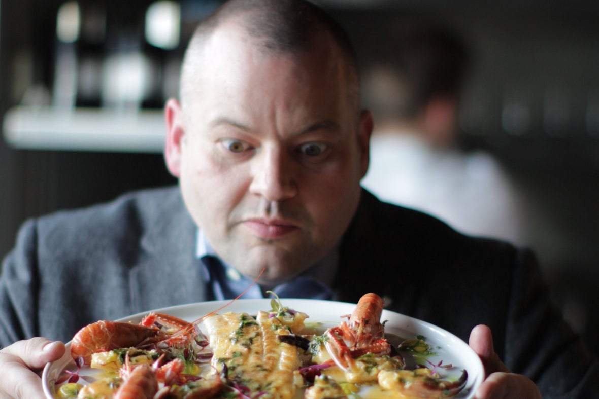 Man holding a plate of seafood.