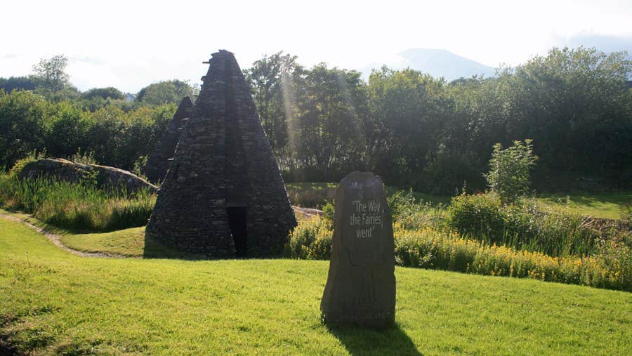 A view of one of the pyramids and to the forefront is the title stone of the park with an Egyptian figure carving on it